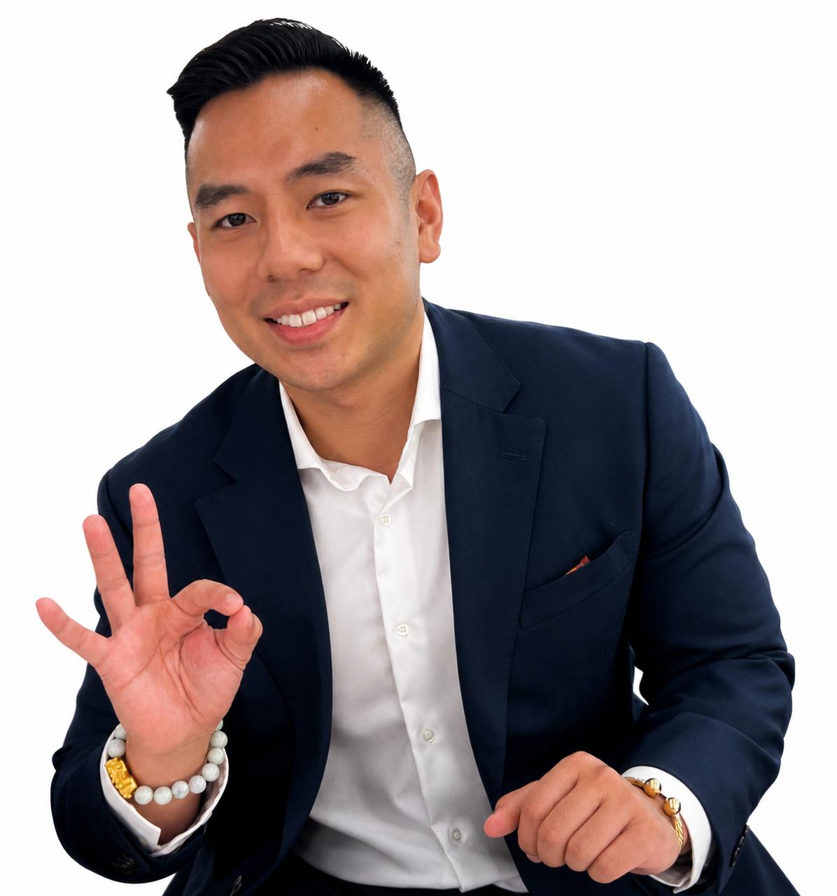 Mari Gimenez smiling in a navy suit and making an OK hand sign